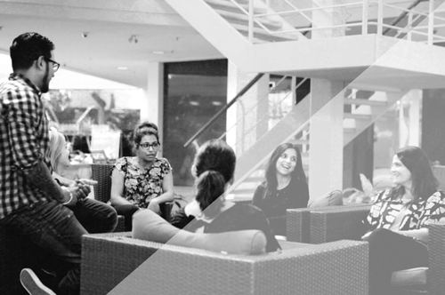 Employees discussing something while sitting in a lounge area at the office